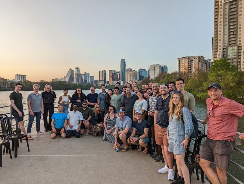 Clouflare group photo outside with the Austin skyline in the background