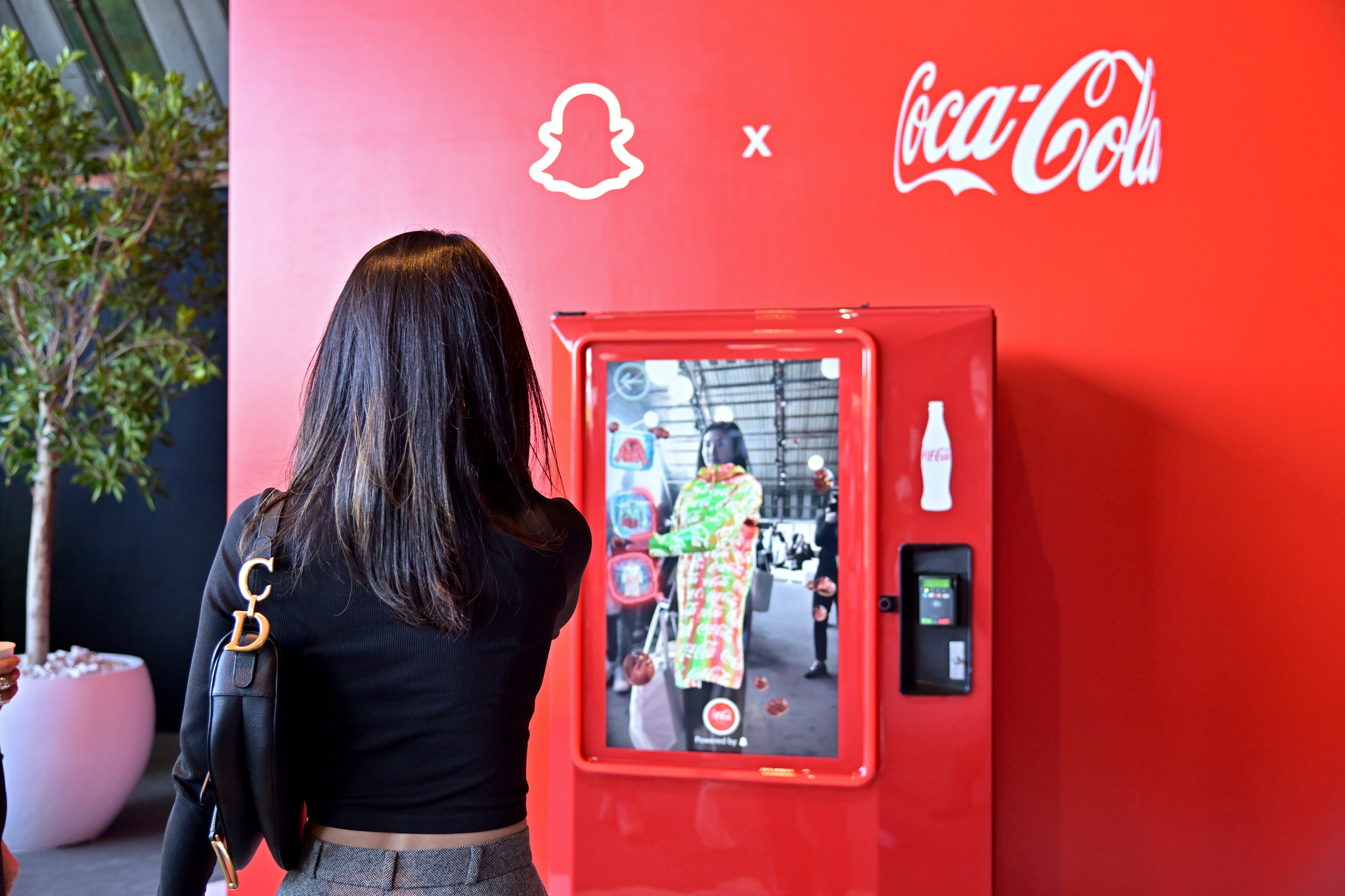 Photo of attendee using the AR-powered Coca-Cola vending machine