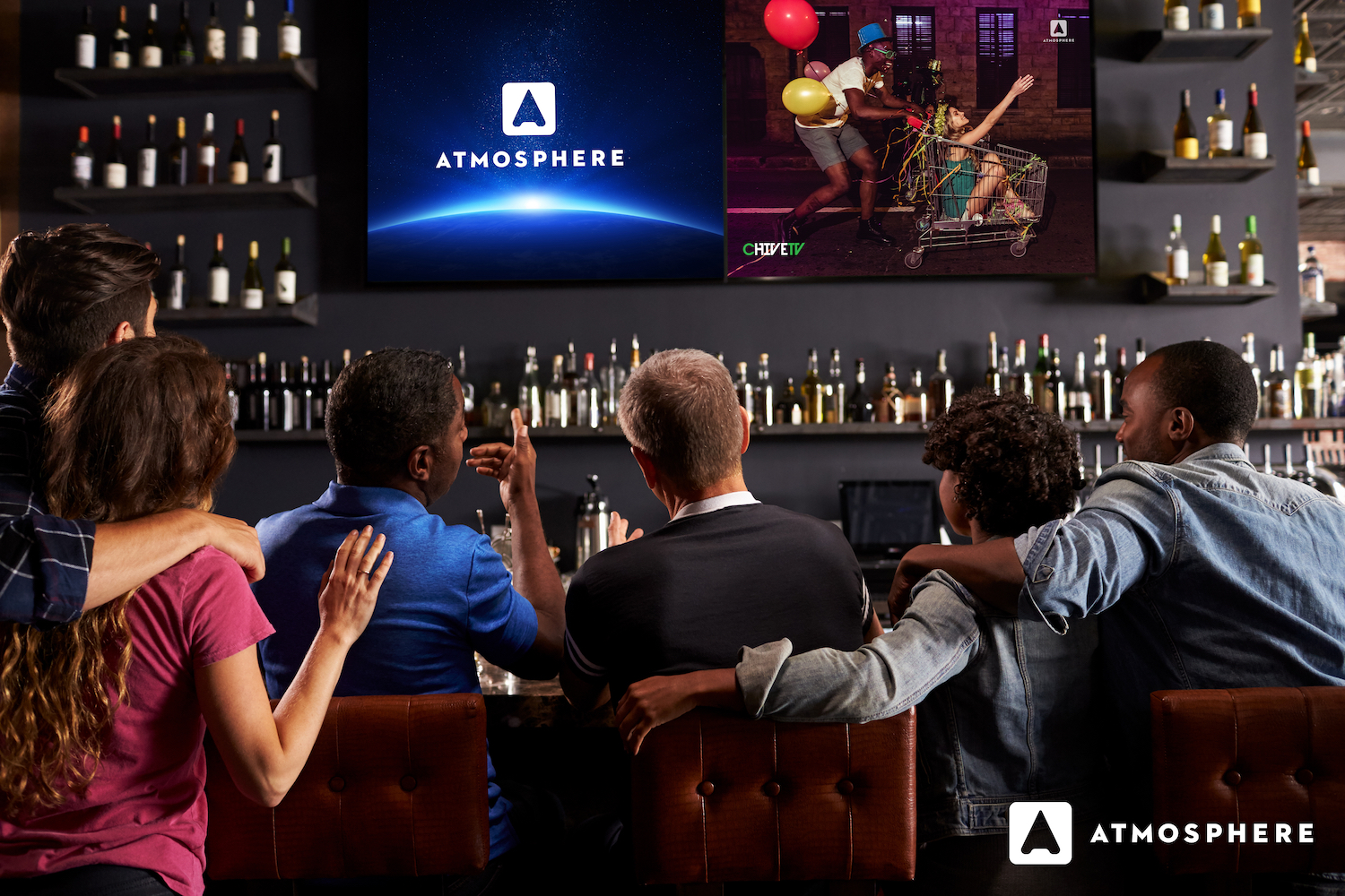 Bar patrons watch Atmosphere programming on a television.