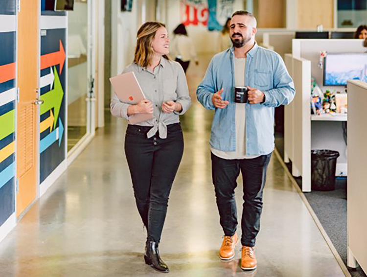 Two BigCommerce team members walking in a hallway at the office