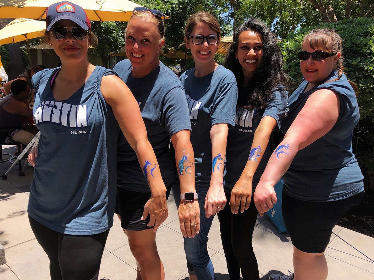 DISCO team members with temporary tattoos of a husky dog on their forearms
