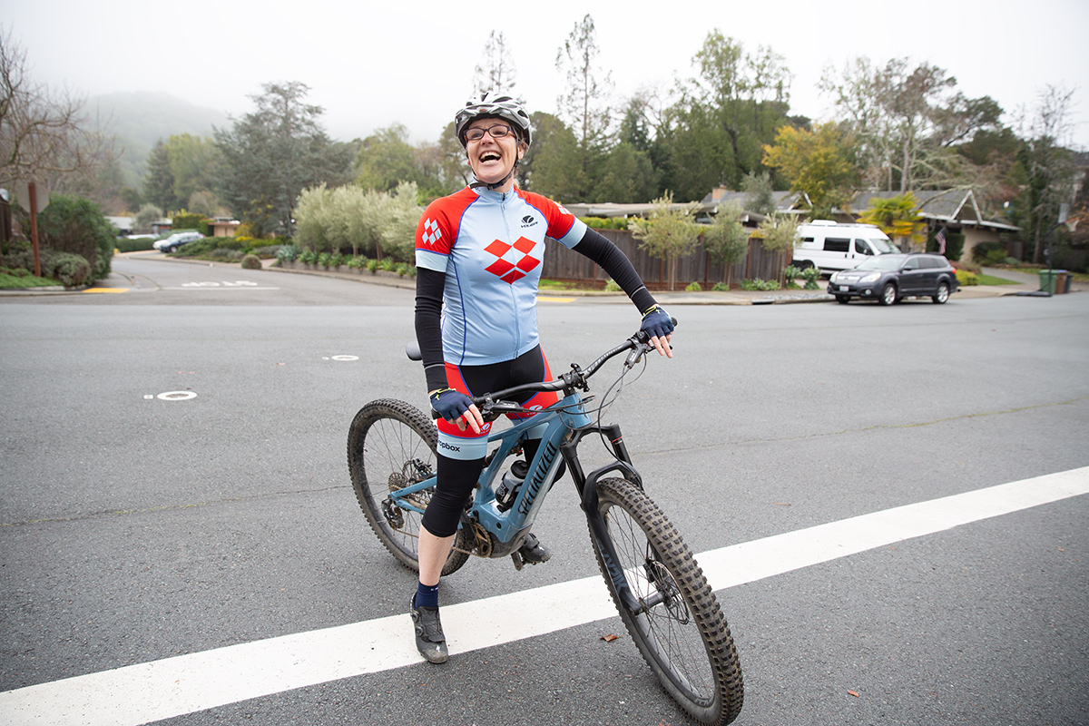 Dropbox team member Susanne Kaufmann on a mountain bike wearing a cycling jersey with the Dropbox logo on it