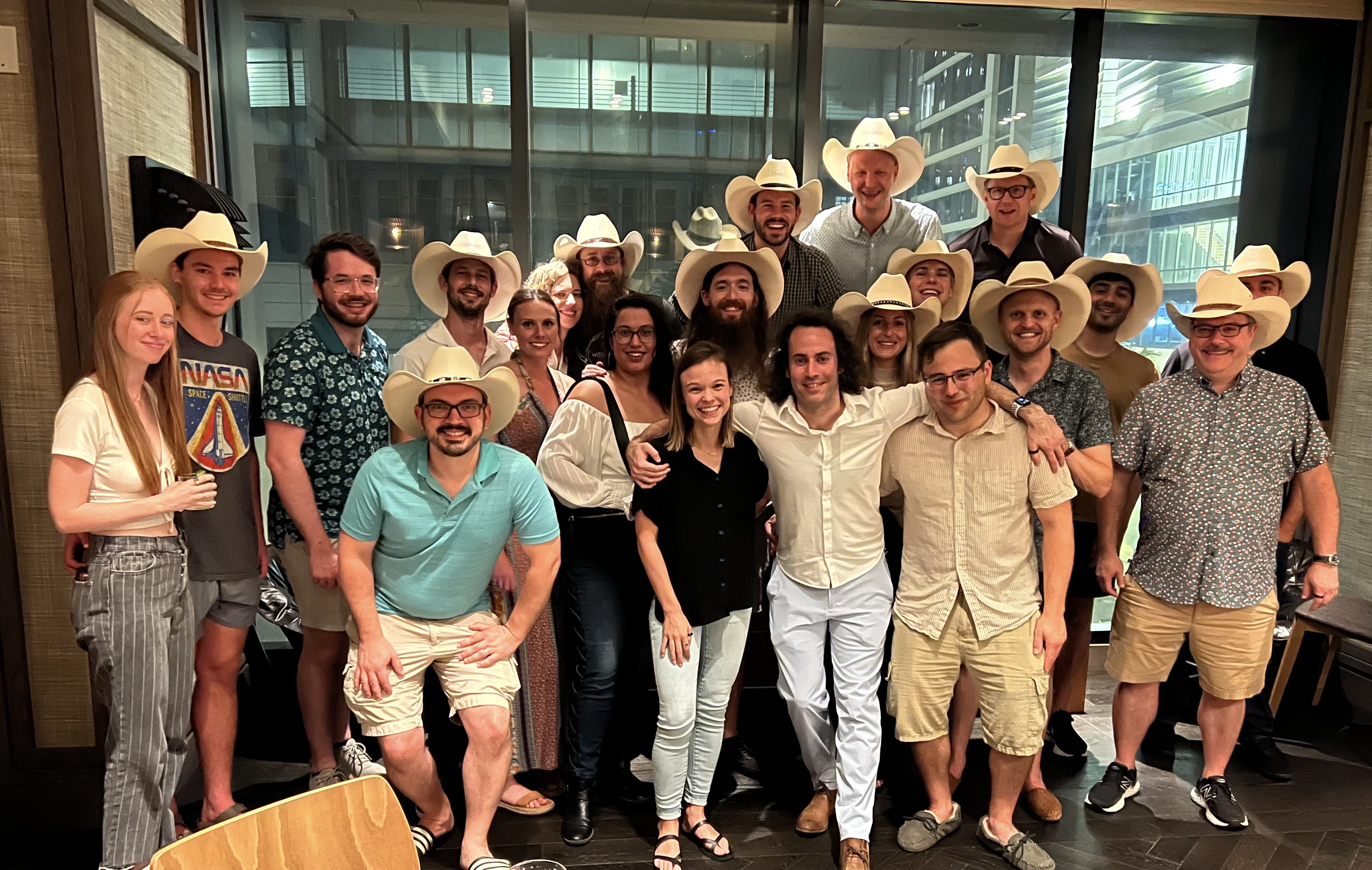 group photo of Unit 410 employees with most wearing white cowboy hats