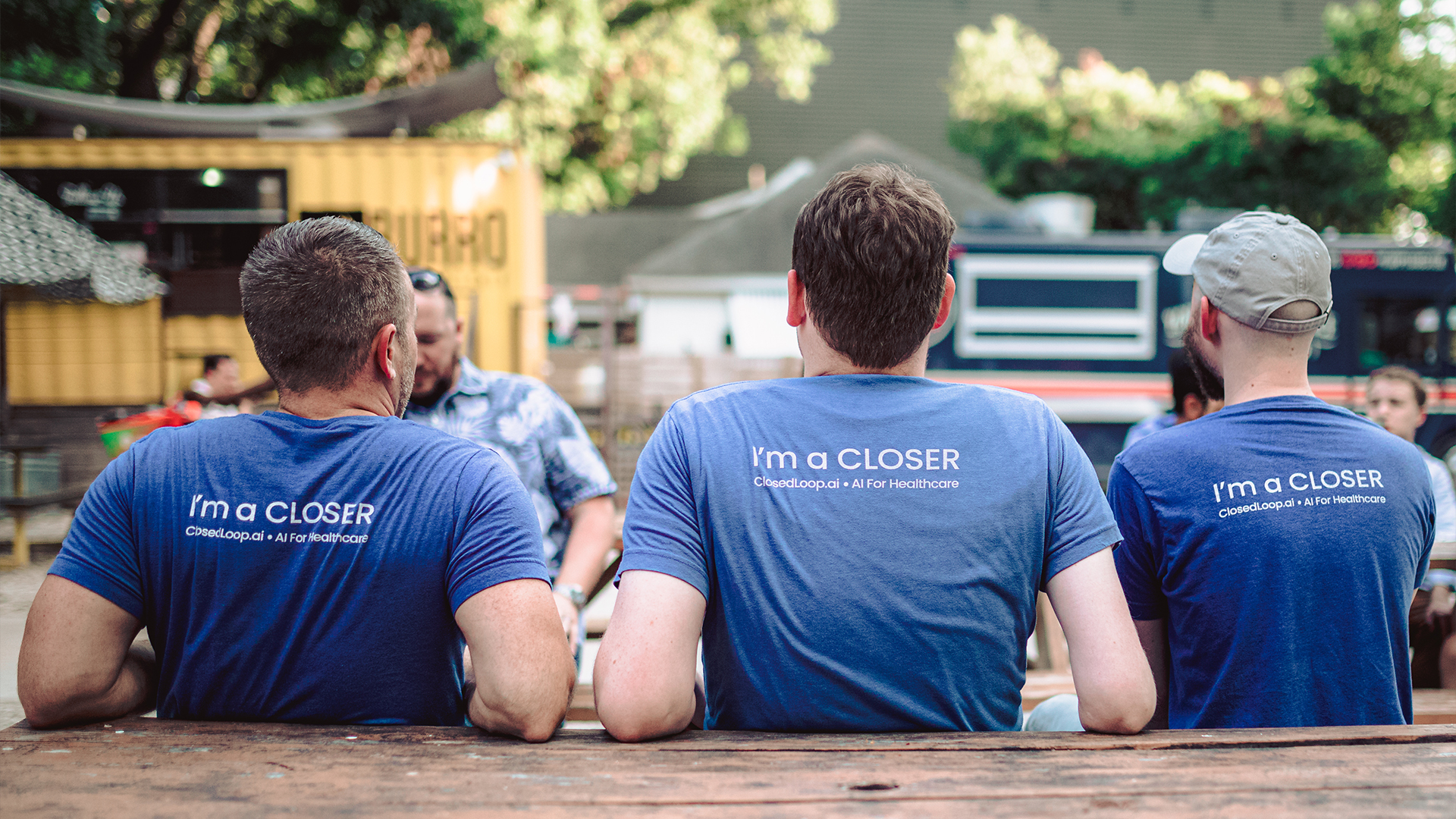 The backs of three ClosedLoop employees, wearing shirts that read “I’m a Closer” 