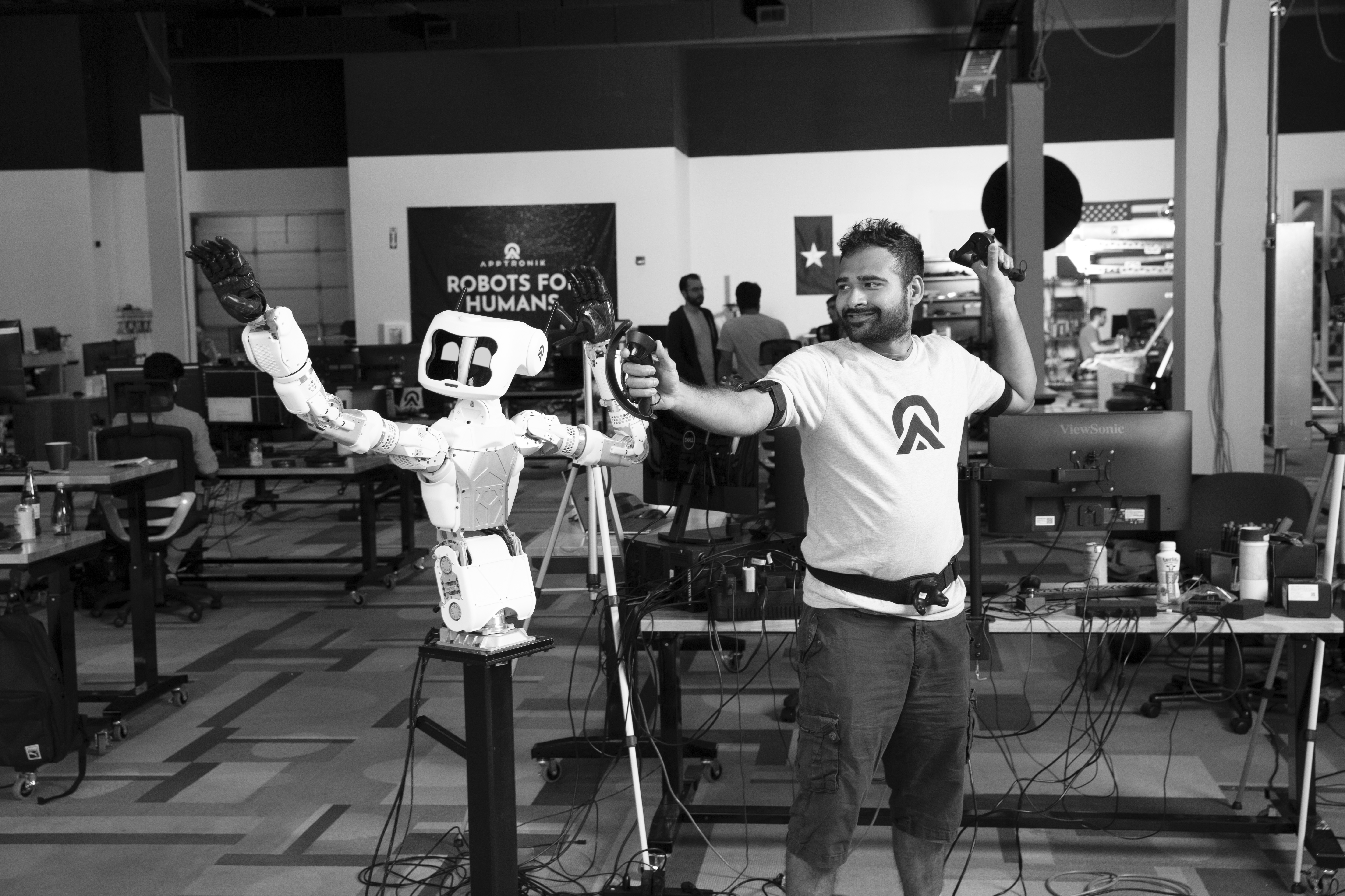 Apptronik black and white photo of Ravi gesturing with a robot.