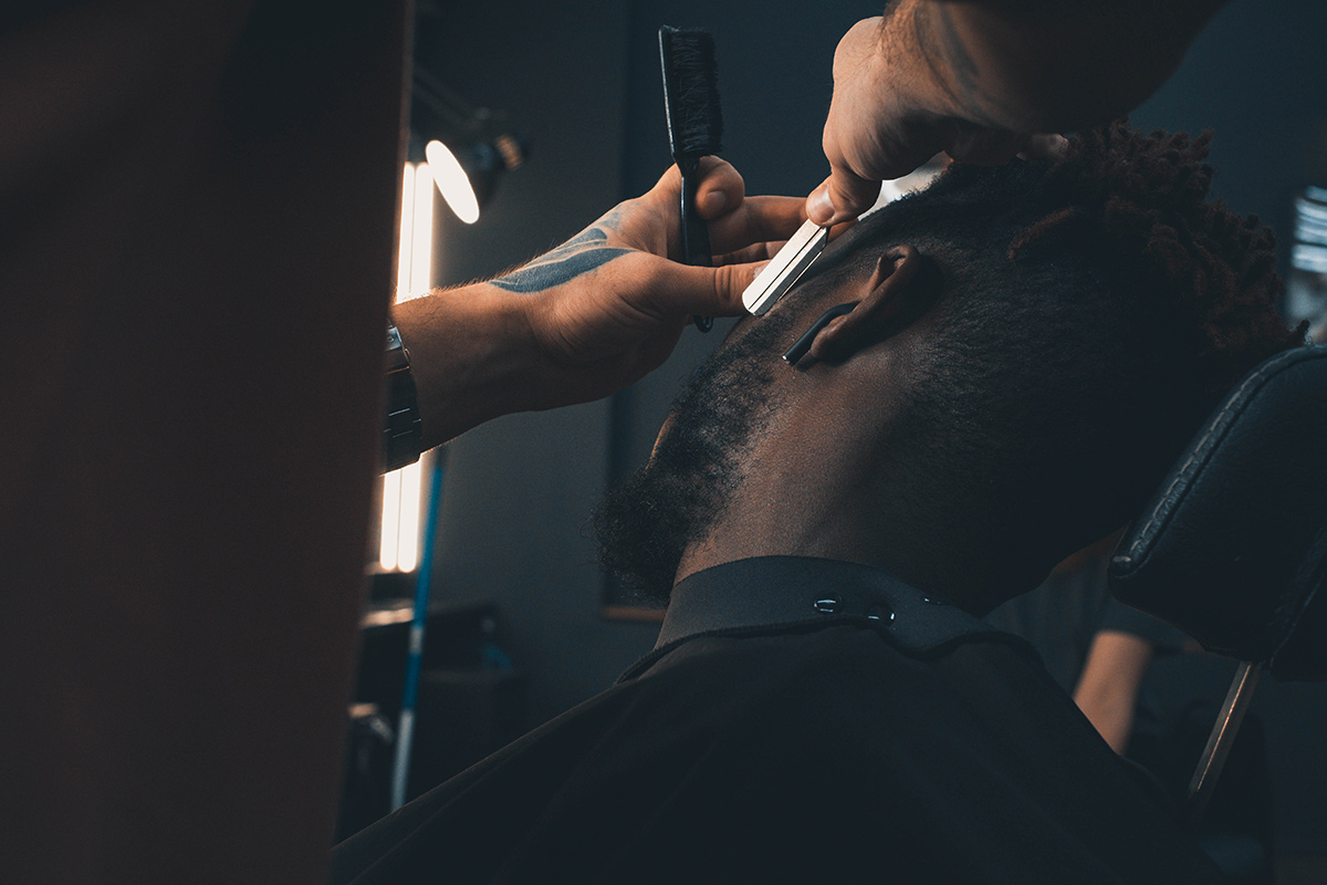 A man in a barbershop getting his beard trimmed