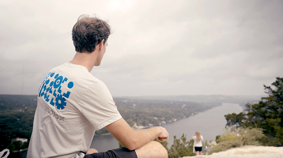 Studio X team member on a hilltop wearing a t-shirt with the company logo