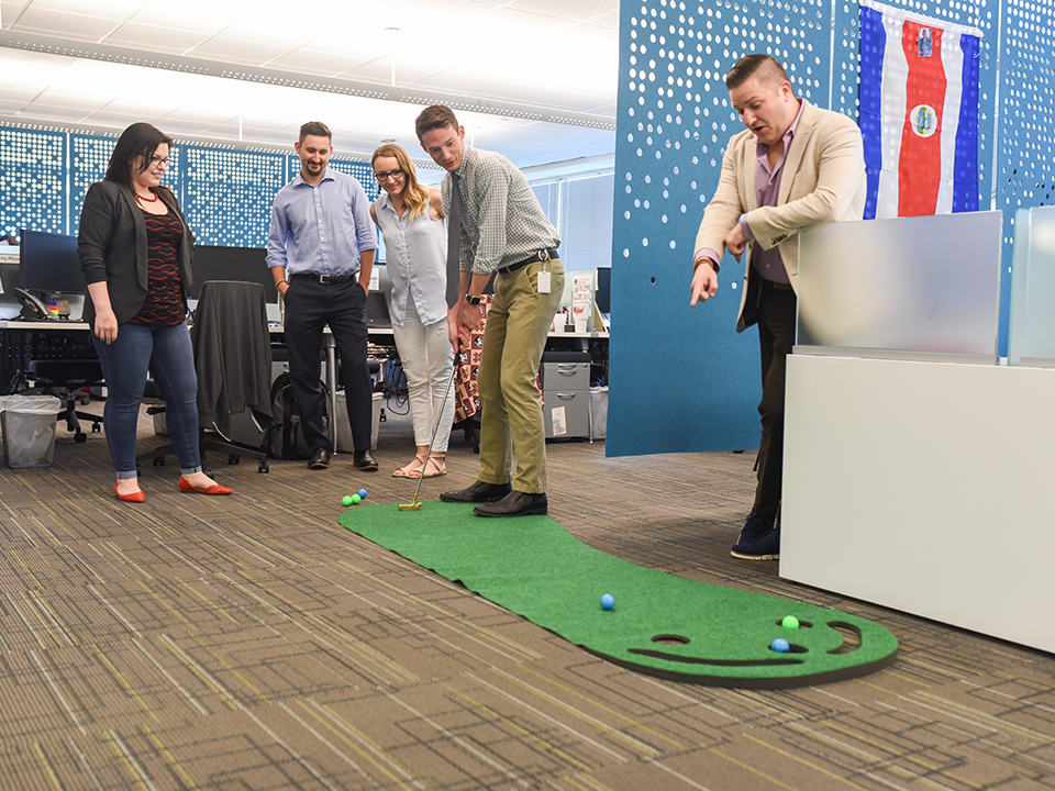 Social Solutions' team playing mini golf in the office