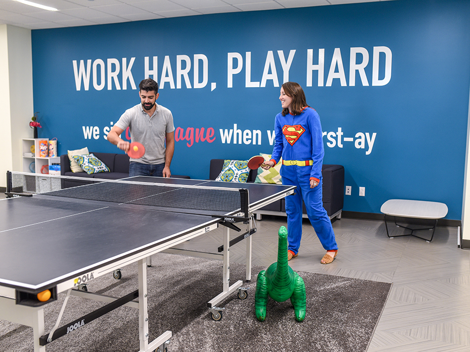 The Social Solutions' team playing ping-pong in the office