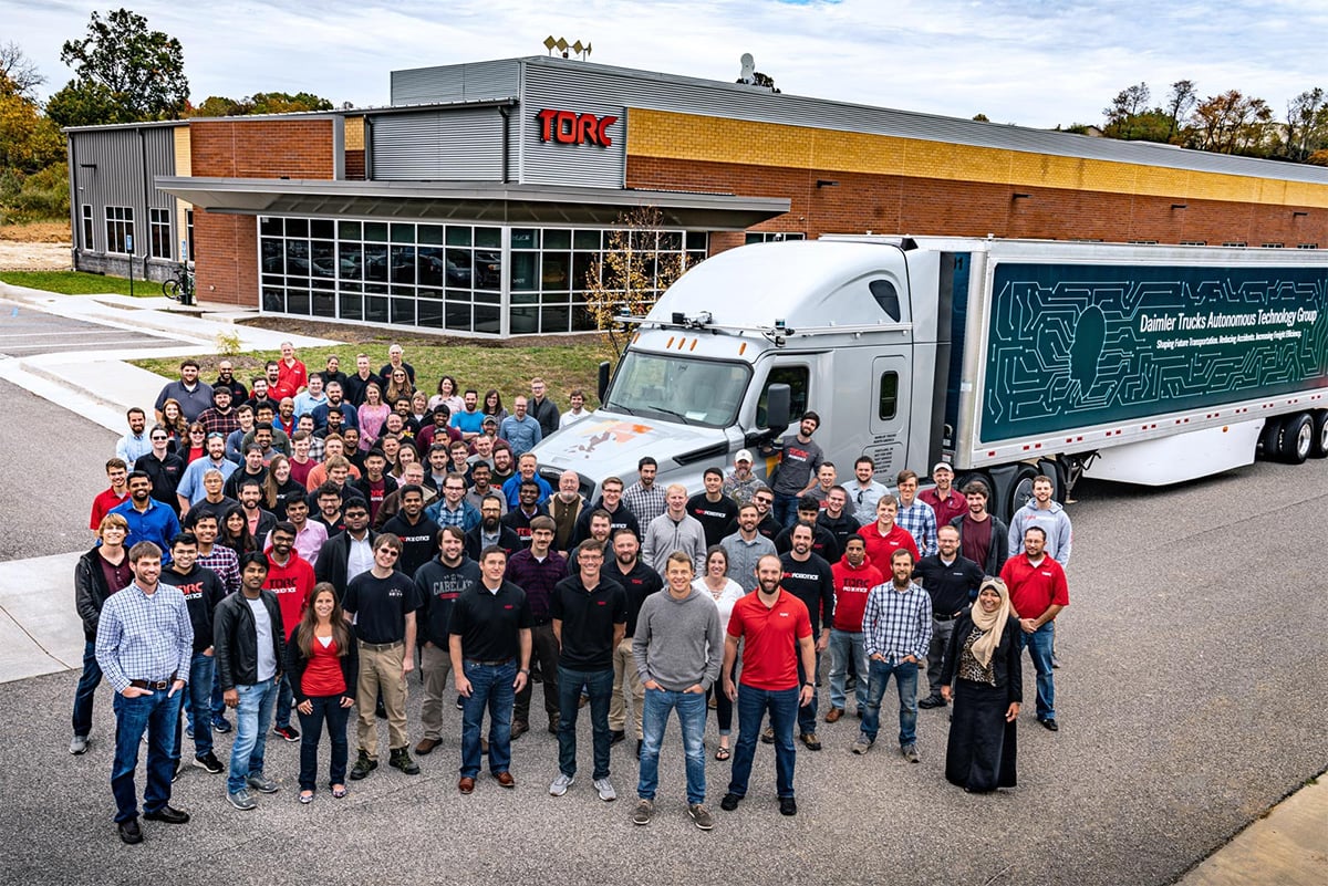 Torc Robotics team photo with a big rig truck outside the office