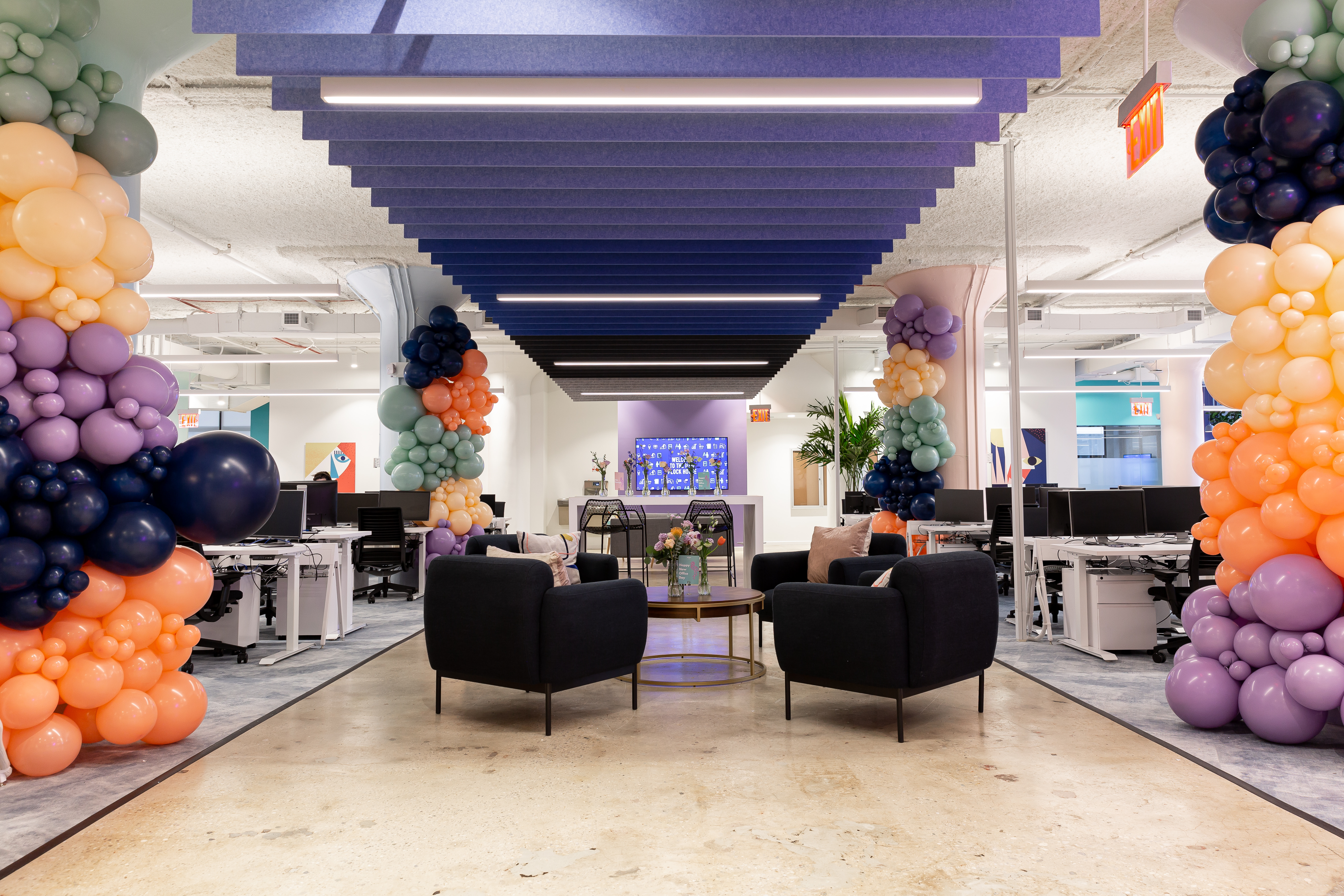 Photo of Yotpo’s NYC office with balloon columns and meeting nooks between bench-desk seating.
