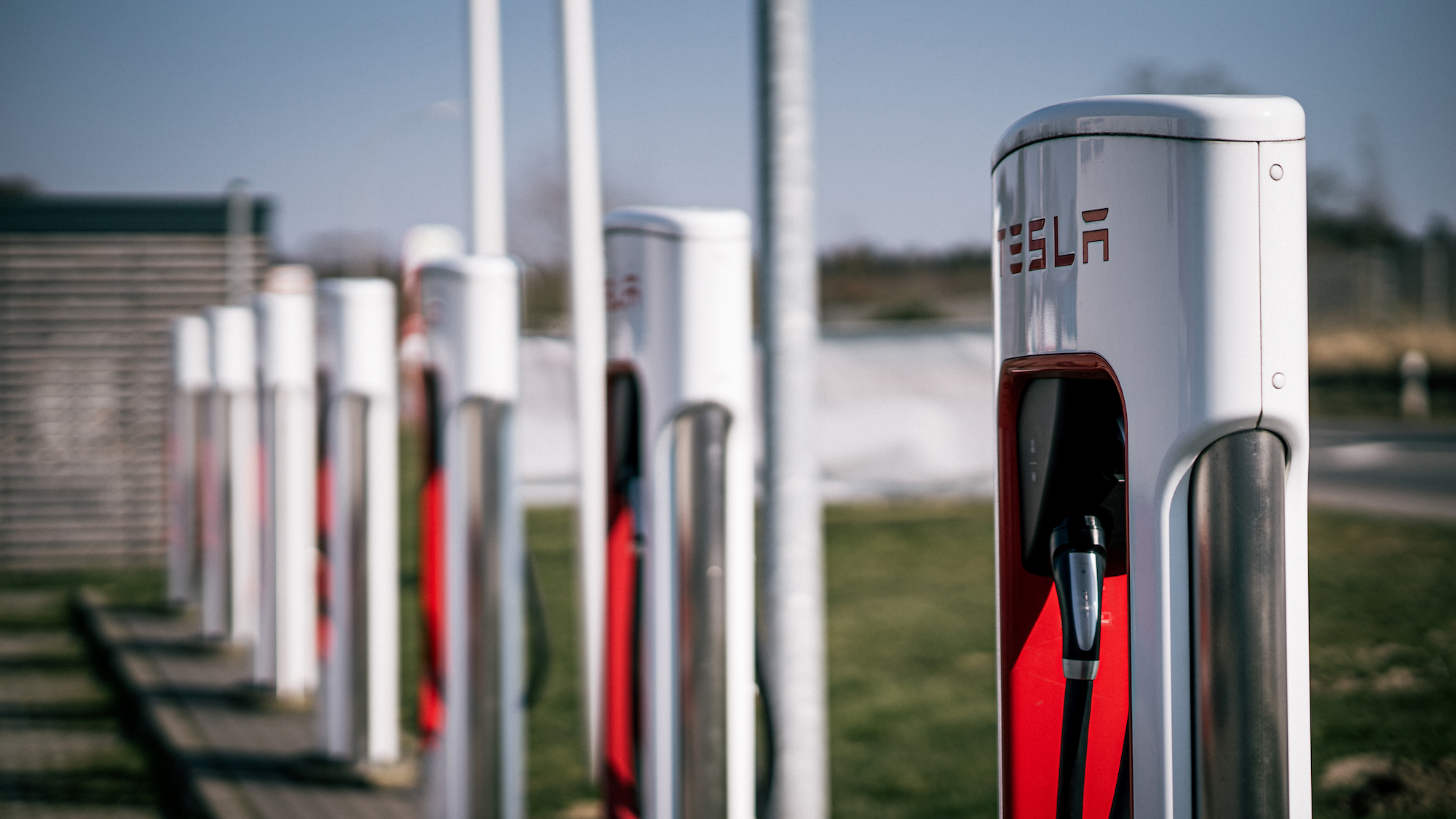 A row of Tesla charging stations is shown.