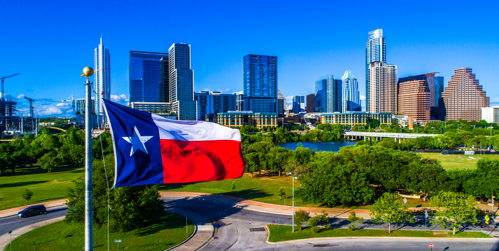 The Texas flag in front of the Austin skyline.