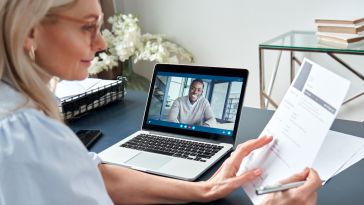 Woman looking a a resume while conducting an interview via video call