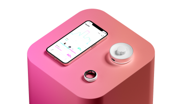 The Happy Ring, pictured with its charger and smartphone app.