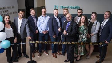 Nomi Health employees gather at its new Austin office for a ribbon cutting ceremony 
