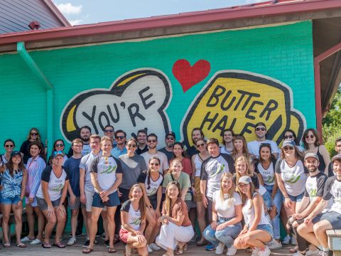 group of people in front of butter half mural